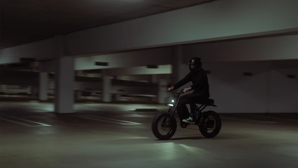 R-Series bike rolling through a parking garage at night
